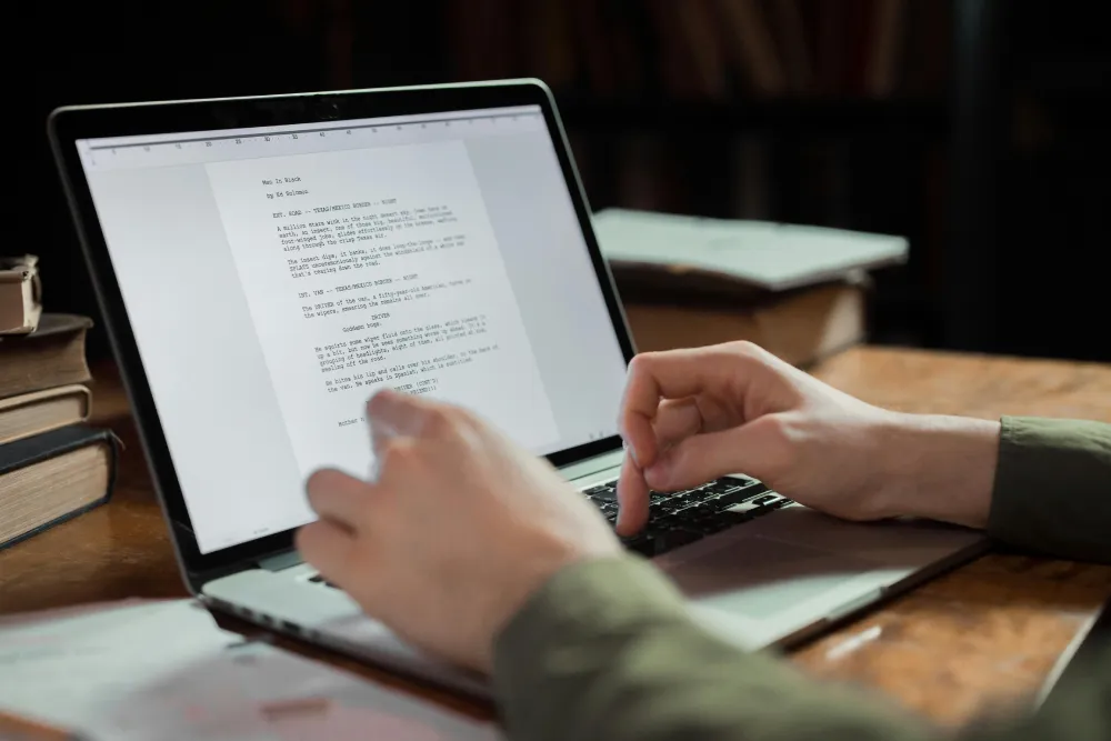 Man writing a script on a laptop